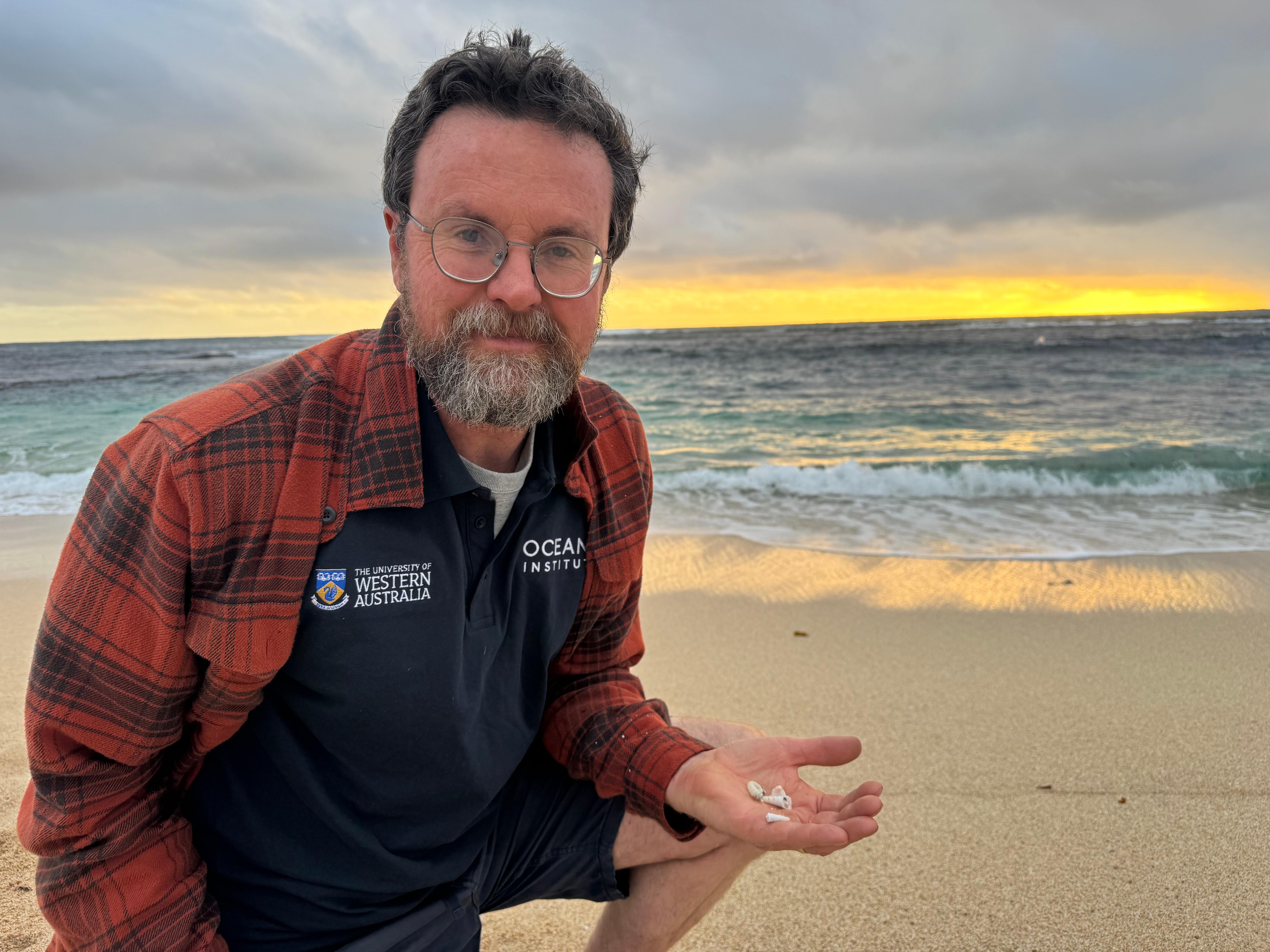 man holding seashells at the beach