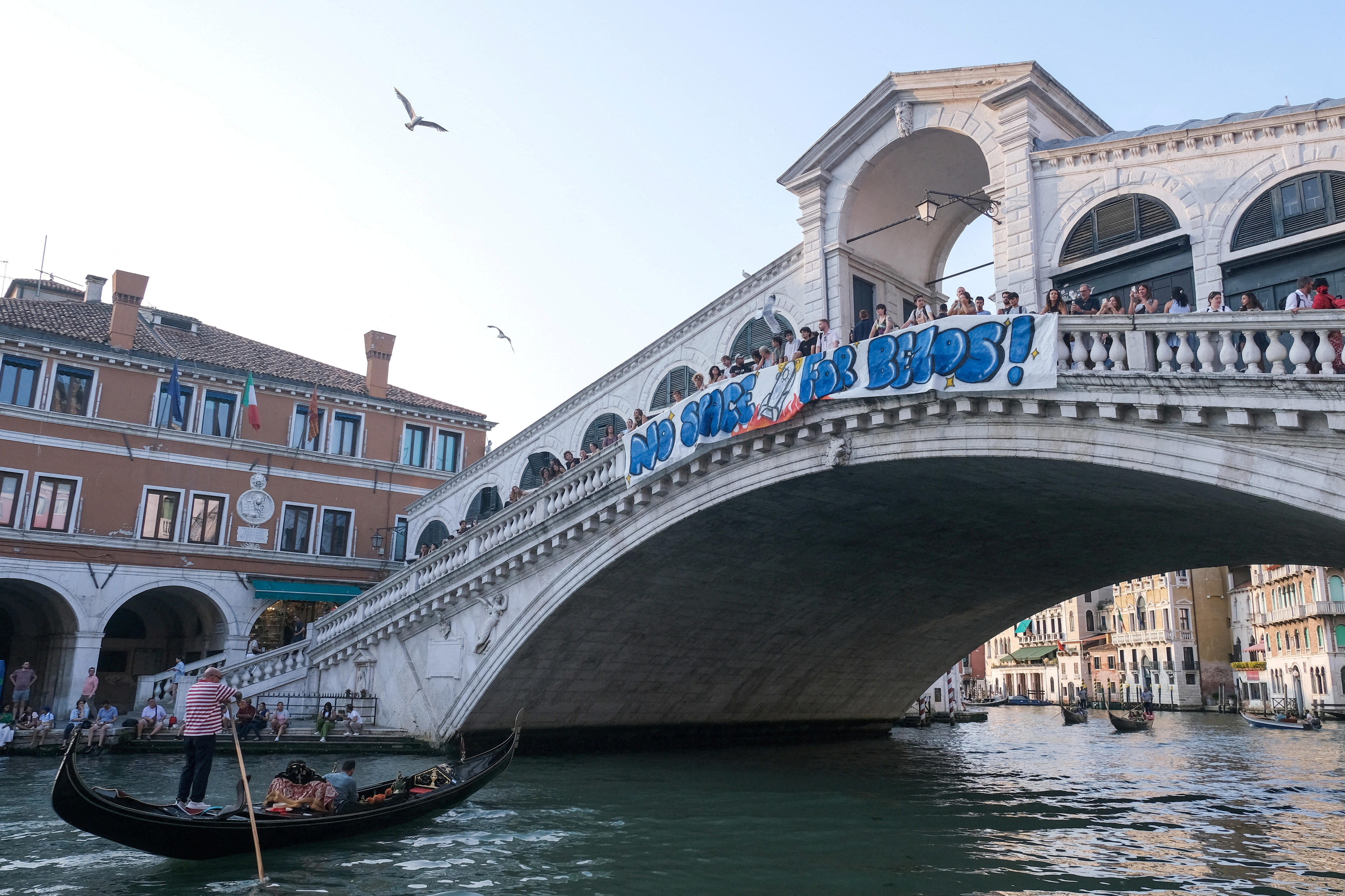 Protesters display a banner reading "No Space for Bezos!" on the Rialto Bridge