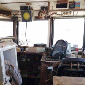 The interior of the wrecked prawn trawler Returner, with damaged equipment, hanging wires and cupbards strewn across the inside.