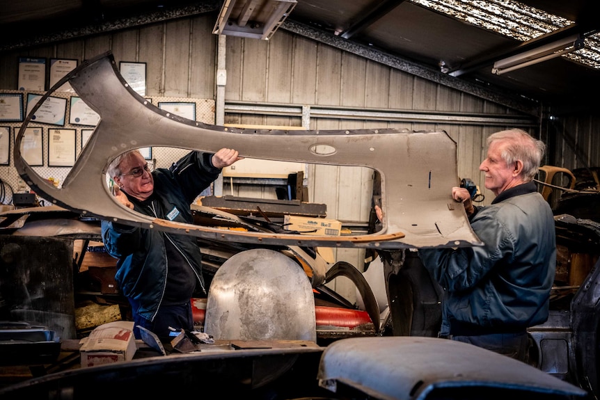 Greg Keenan and a friend maneuverer a panel into place.