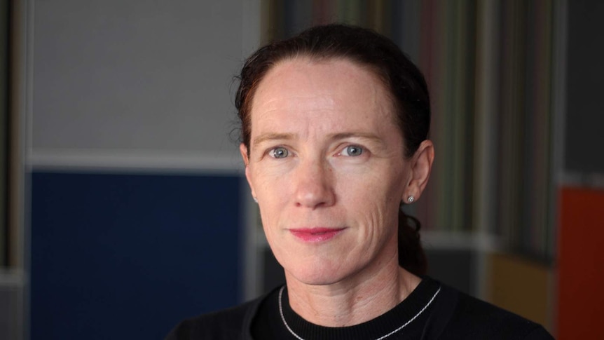 Psychologist Joann Lukins stands in a room with coloured walls