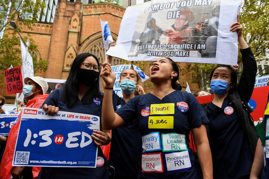 nurses holding placards at a protest over wages and conditions