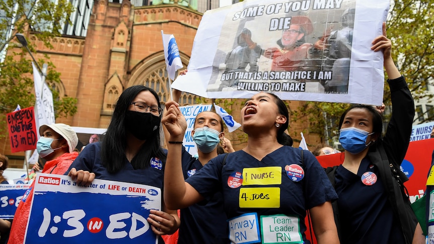 nurses holding placards at a protest over wages and conditions