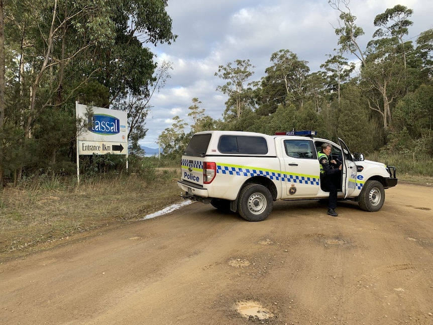 A police car blocking a dirt bush road