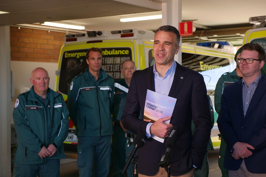 Premier Peter Malinauskas and Health Minister Chris Picton with ambulance officers standing behind them.