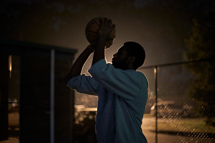 A nighttime pic of Buru about to take a shot on the basketball court