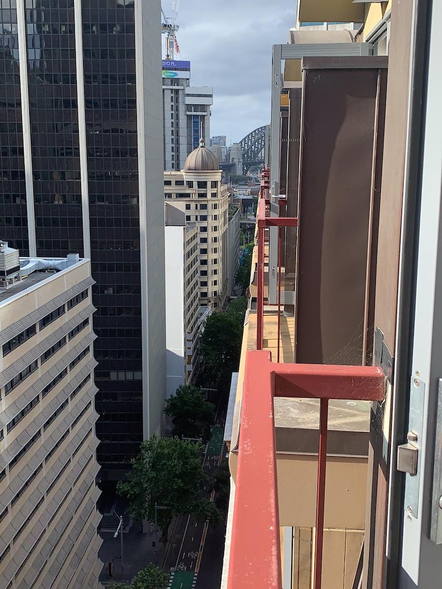 View from a hotel of city buildings and the Sydney Harbour Bridge.