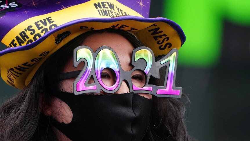 A woman wears '2021' numeral glasses in advance of New Year's eve in Times Square amid the coronavirus disease (COVID-19) pandemic in the Manhattan borough of New York City, New York, U.S., December 21, 2020.