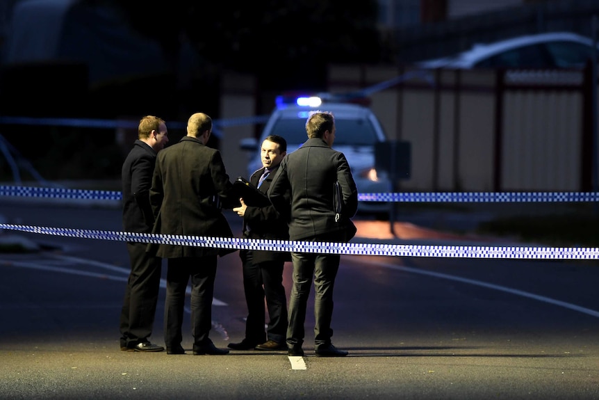 Police stand behind police tape after a fatal shooting in Narre Warren.