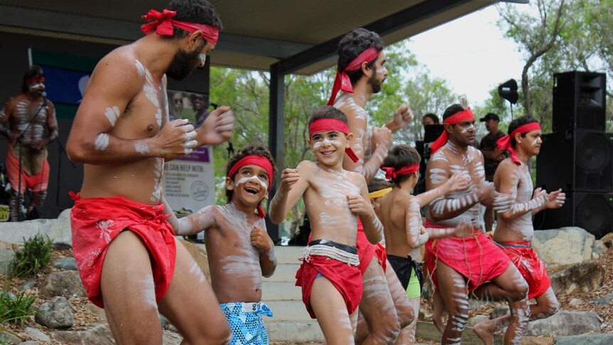 An Aboriginal dance troupe in red loin cloths