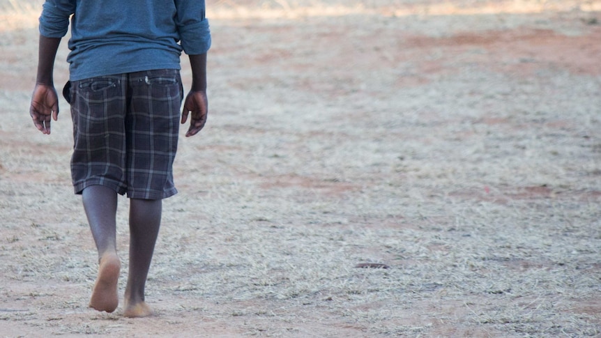 An Aboriginal boy walks alone.