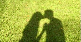 A shadow of a couple kissing.