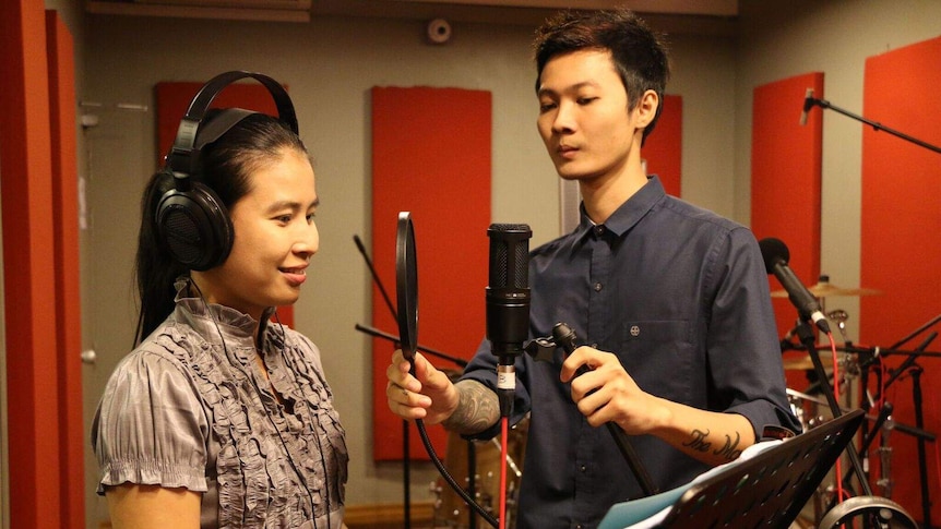 Two voice artists in a recording studio recording a part of the Ma Ma Oo radio drama