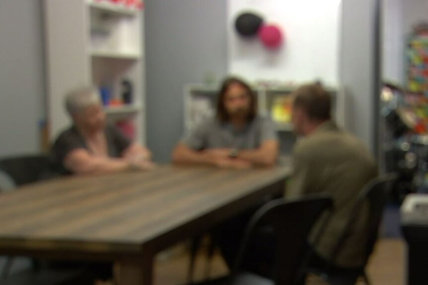 Blurred photo of three people sitting in the kitchen of the Perth young drug rehabilitation centre.