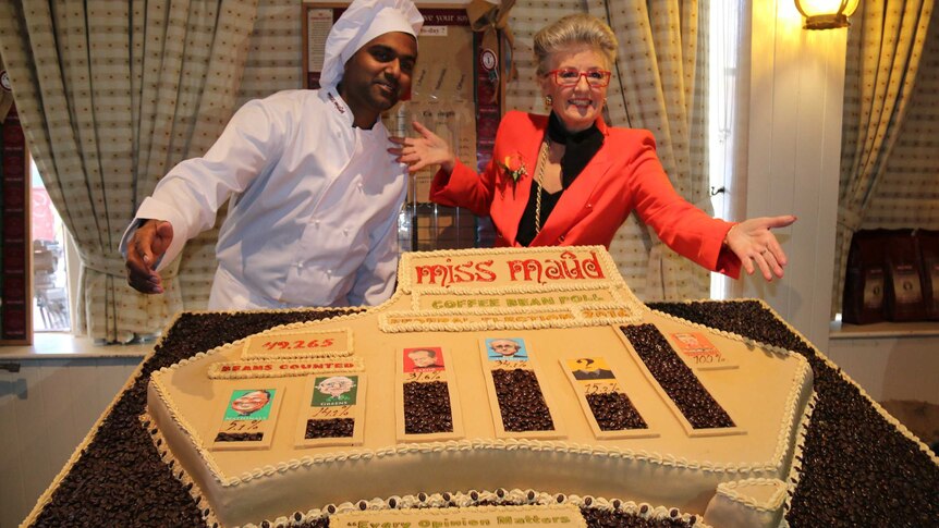 Miss Maud and Chris Nayaranasami pose with a giant Australia-shaped cake.