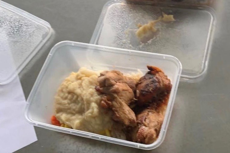 A plastic takeaway container with mashed potato and fried chicken.