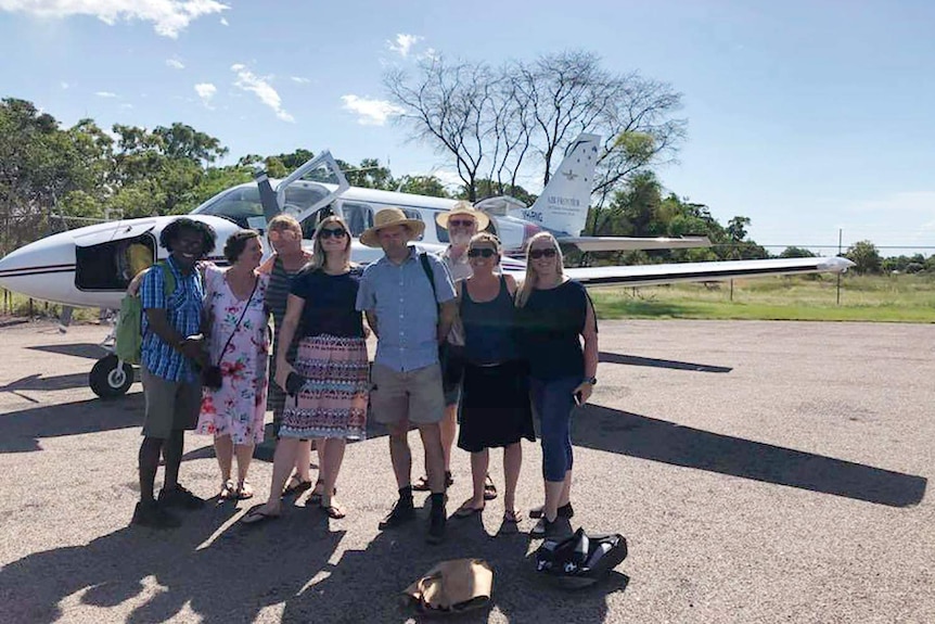 A group of Maningrida residents standing in front of the plane they chartered to Dawrin.