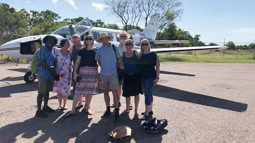 A group of Maningrida residents standing in front of the plane they chartered to Dawrin.