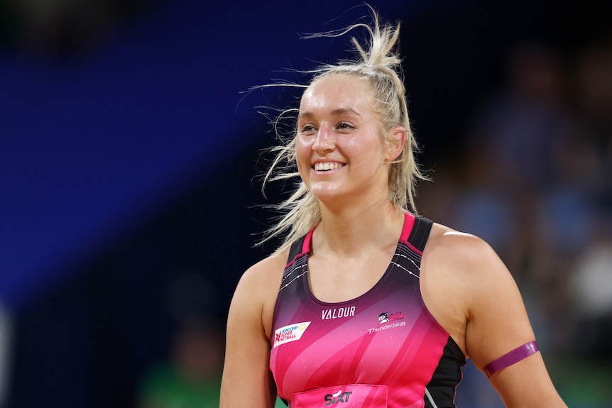Tayla Williams smiles in her Adelaide Thunderbirds pink dress