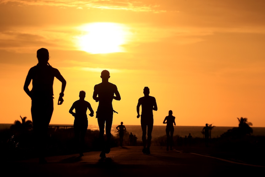 Runners are shown in silouette with a sunset backdrop