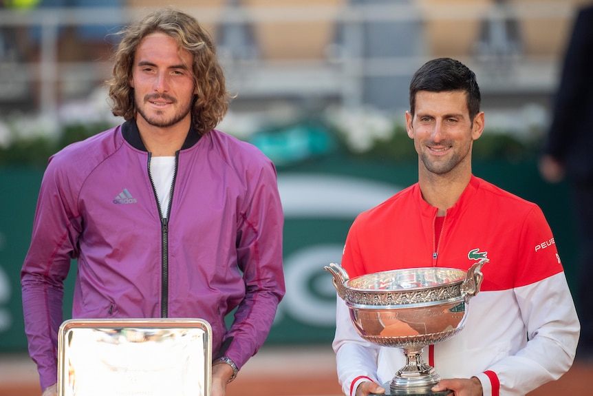 Stefanos Tsitsipas and Novak Djokovic with their respective French Open trophies in 2021.