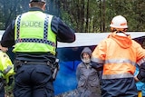 Police speak with anti-logging protesters.