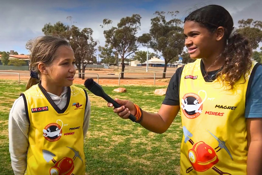 Two girls in yellow football jumpers. 