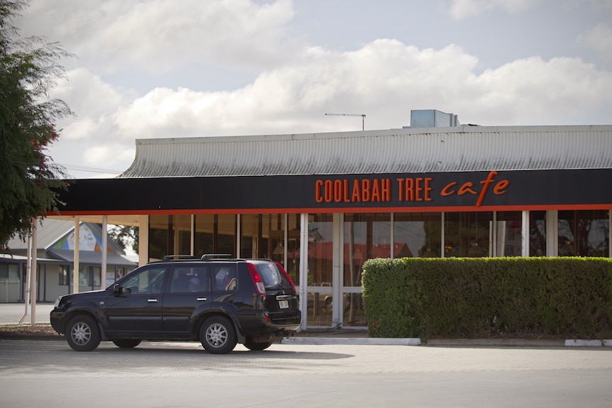 The front of the Coolabah Tree Cafe with the cafe's name in orange letters.  A vehicle is parked on the left.