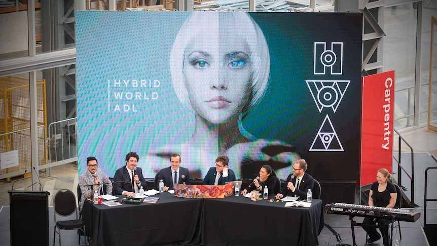 An image of people sitting at a conference table in front of a banner.
