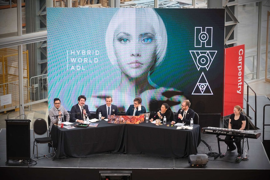 An image of people sitting at a conference table in front of a banner.