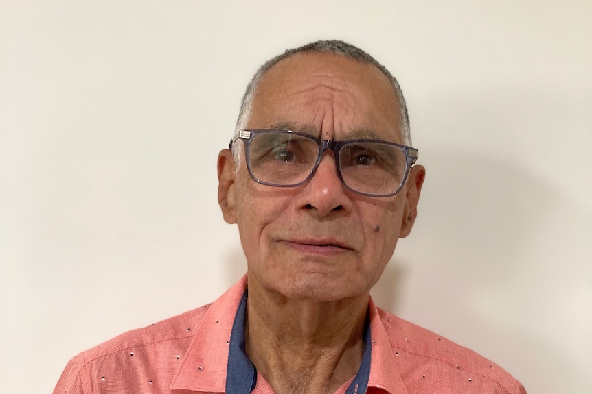 A smiling elderly man wearing glasses