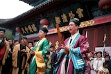 Daoist priests conduct prayers for a group of elderly pilgrims