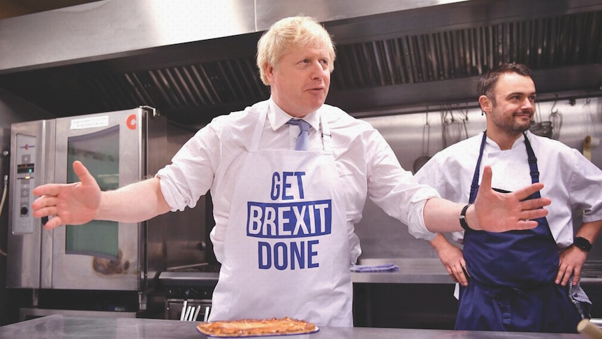 Boris Johnson stands in a kitchen behind a pie. His apron reads: Get Brexit done.