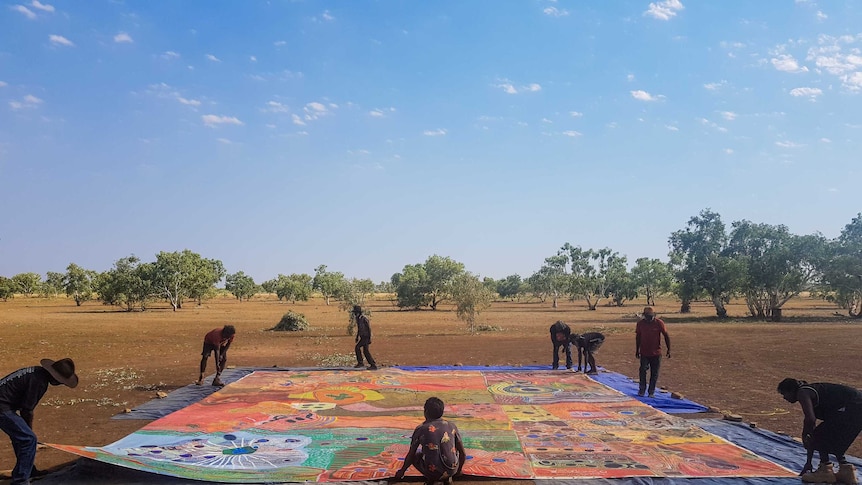 Ngurrara Canvas II being laid in the same place it was painted 20 years prior.