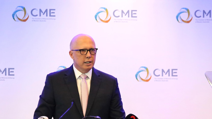 Dutton stands at a lectern speaking, a poster with CME logos behind him.