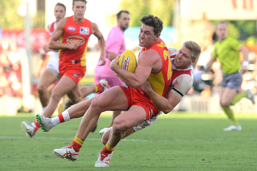 Gold Coast's Danny Stanley is tackled by Sydney's Dan Hanneberry
