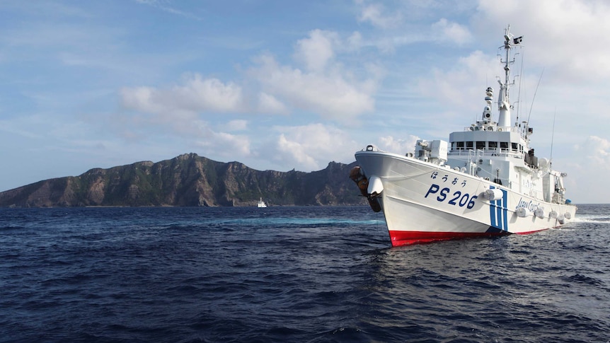 A Japanese Coast Guard vessel sails in front of one of the disputed islands in the East China Sea.