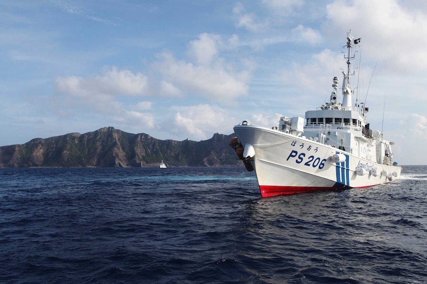 A Japanese Coast Guard vessel sails in front of one of the disputed islands in the East China Sea.