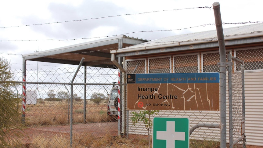 Imanpa health clinic with a sign out the front on barbed wire fence.