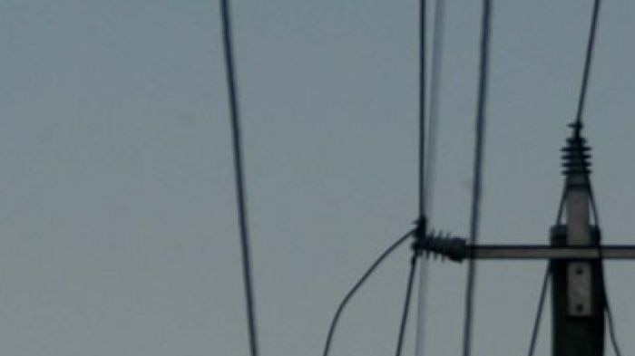 The full moon rises over powerlines