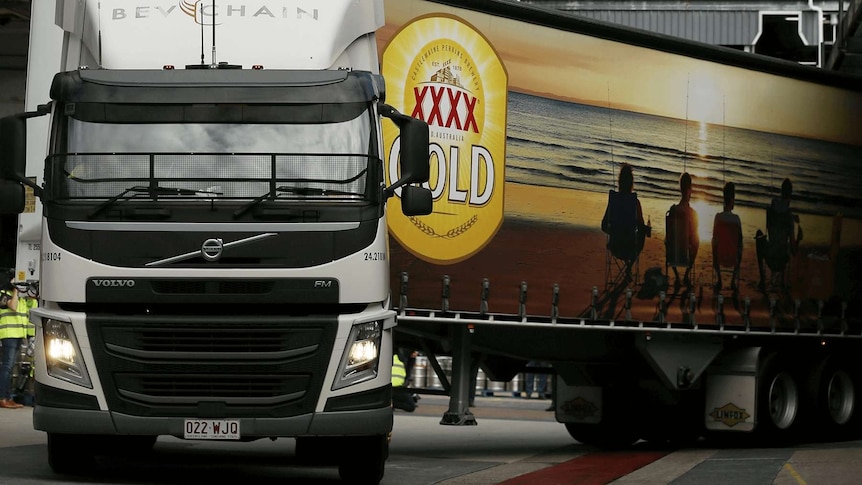 A XXXX Gold truck drives out from a Lion facility in Brisbane. It has XXXX Gold branding on the side of it.