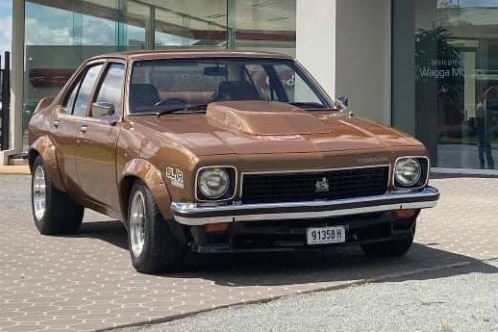 Gold coloured car with a cowl induction hood scoop.