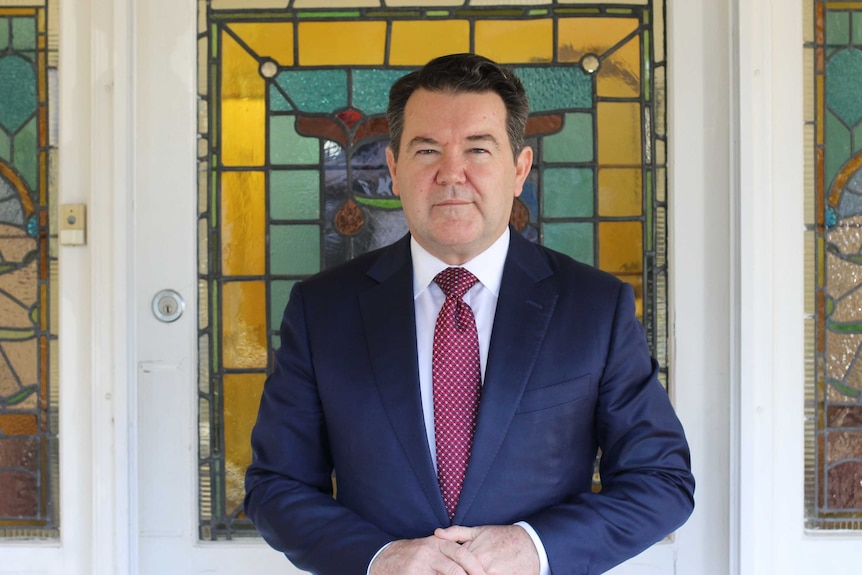 Dean Smith standing in front of doorway with stained glass windows