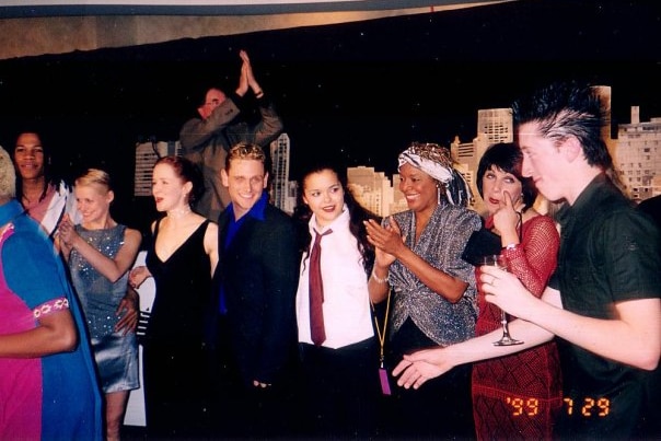 A group of six women and three men line up for a photograph in formal wear at the opening night of Fame in 1999.