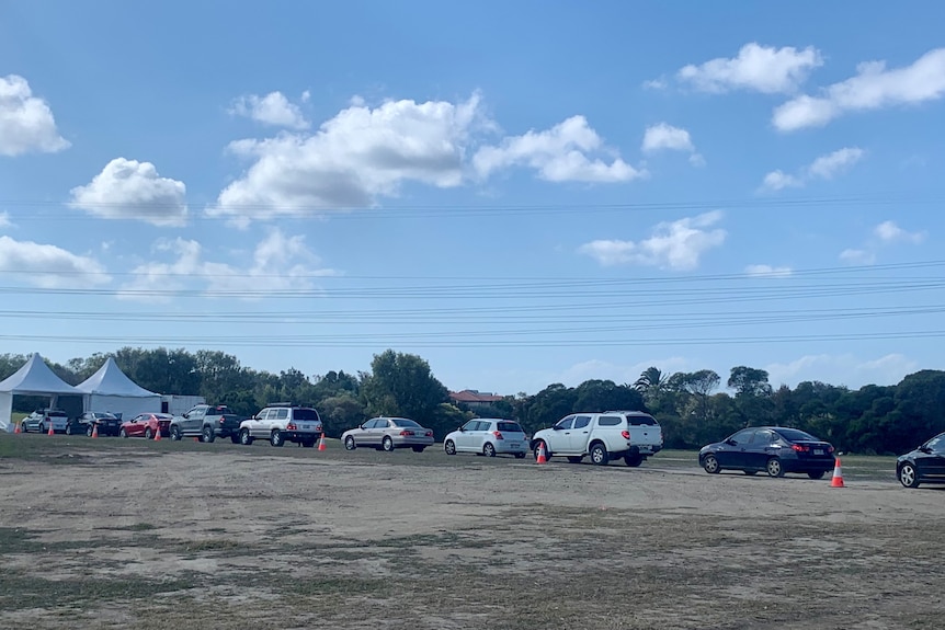 A long line of cars ahead of a tent.