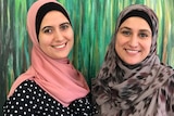 Two smiling ladies wearing hijabs pose for the camera