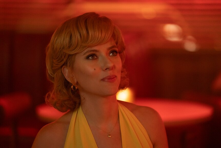 A still from the movie Fly Me to the Moon with Scarlett Johansson in 50s clothes in a diner, red light
