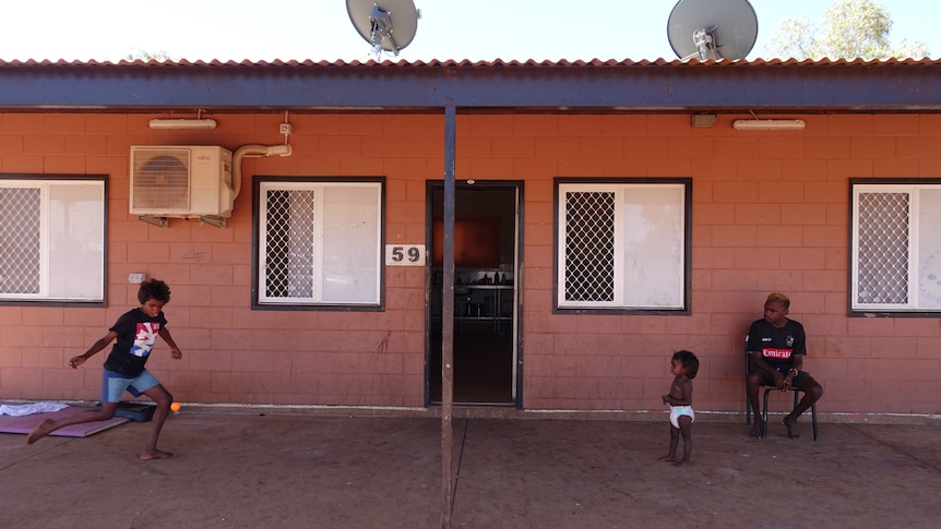 Veronica Tilmouth's grand-niece and nephews play outside her red brick home.