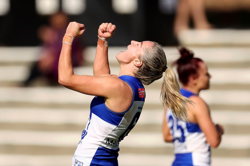 A Kangaroos AFLW player celebrates a goal.