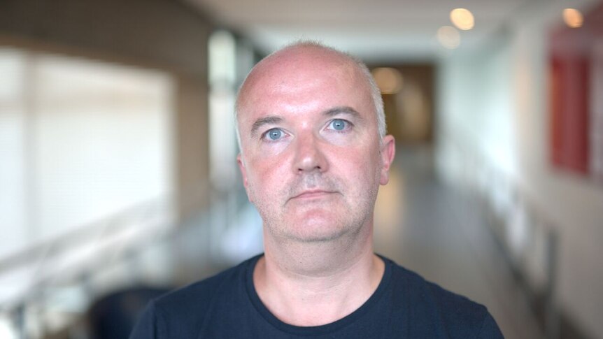 Headshot of Brian Meechan: caucasian, blue eyes, balding